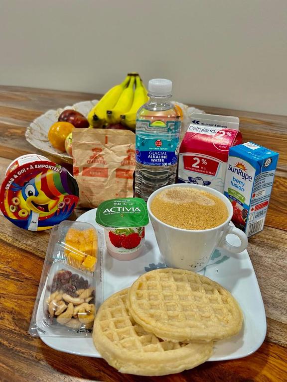 a table with a plate of waffles and a cup of coffee at Romantic Luxury Retreat with Private Sauna & Spa, Pet Friendly, Elkside Hideout B&B in Canmore