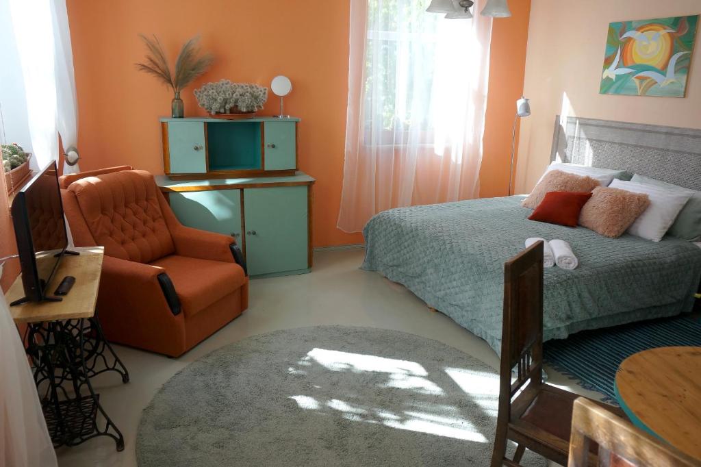 a small bedroom with a bed and a chair at Uliha Apartamenti in Liepāja