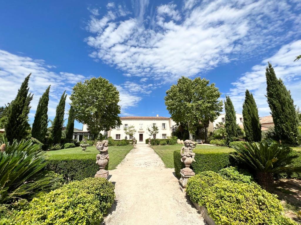 ogród z ścieżką przed budynkiem w obiekcie Chateau de la Clapiere w Hyères