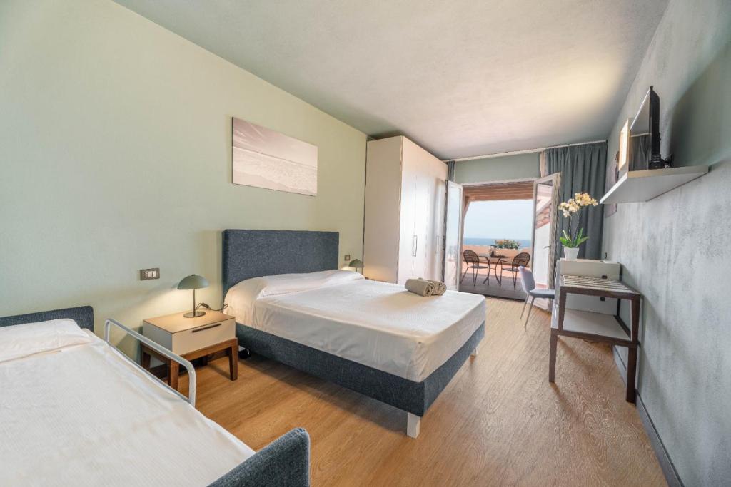 a hotel room with two beds and a balcony at Hotel Baia Imperiale in Campo nell'Elba