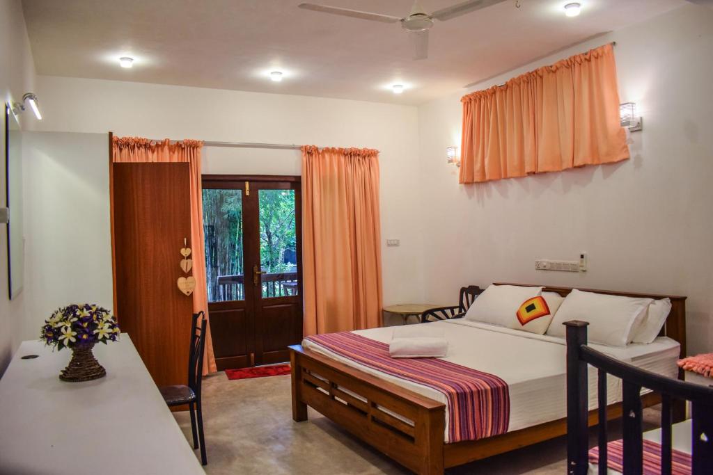 a bedroom with a bed and a table and a window at Lawrence Villa in Weligama