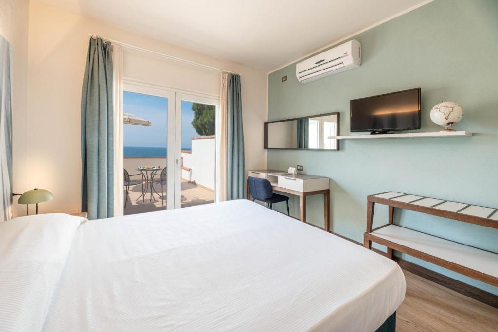 a hotel room with a bed and a view of the ocean at Hotel Baia Imperiale in Campo nell'Elba