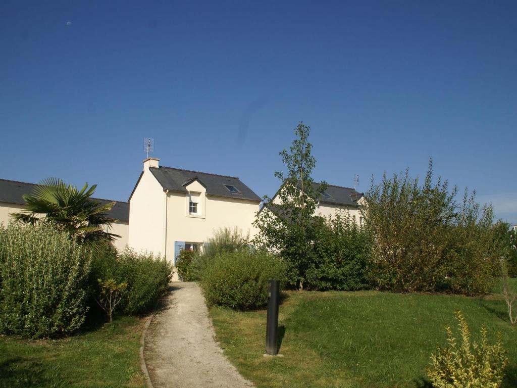 una casa blanca con un camino que conduce a un patio en Pleasant Breton holiday home near the bay of Douarnenez, en Crozon