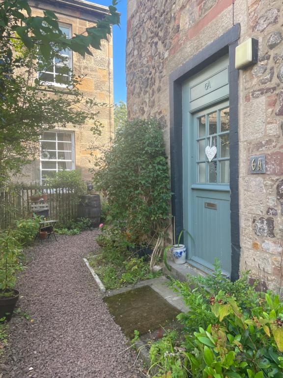 una porta blu sul lato di un edificio di East Linton Flat a East Linton