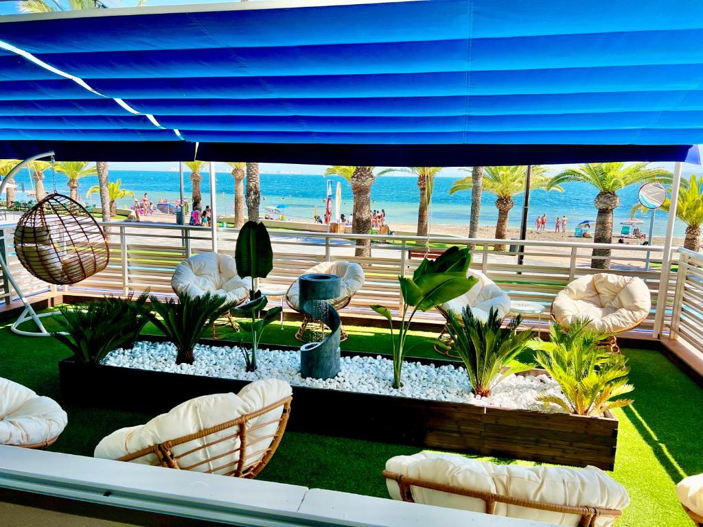 Blick auf eine Terrasse mit Stühlen und den Strand in der Unterkunft Hotel Neptuno in San Pedro del Pinatar