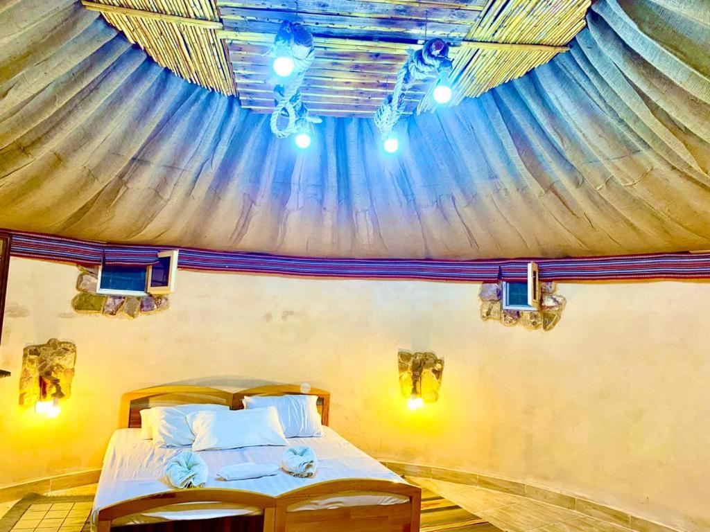 ein Schlafzimmer mit einem Baldachin und einem Bett in einem Zimmer in der Unterkunft Pink city cottage in Wadi Musa