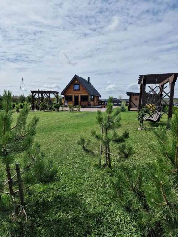 a house in the middle of a field with trees at Žaliūkių pirtis in Žaliukai