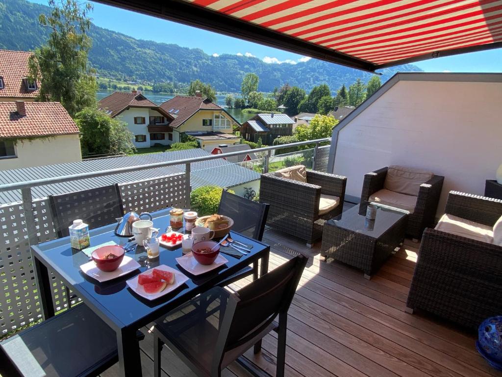un tavolo con cibo in cima a un balcone di FeWo mit Seeblick a Bodensdorf