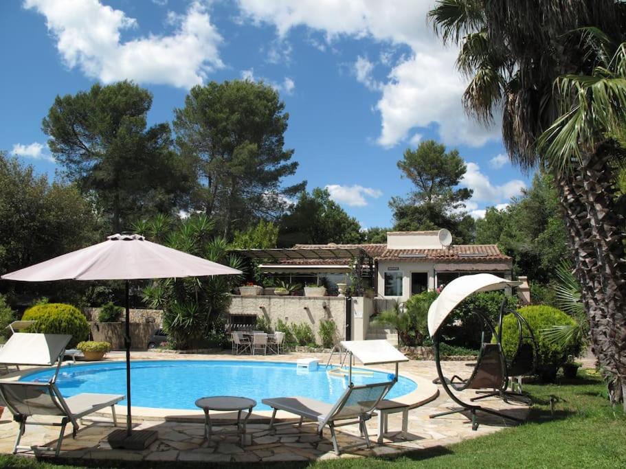 - une piscine avec des chaises et un parasol dans l'établissement Les Portes Du Soleil, à Bagnols-en-Forêt