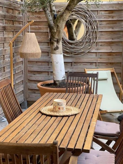 une table et des chaises en bois avec un arbre et une lampe dans l'établissement Maison de maître dans le village, bord de mer, à Torreilles