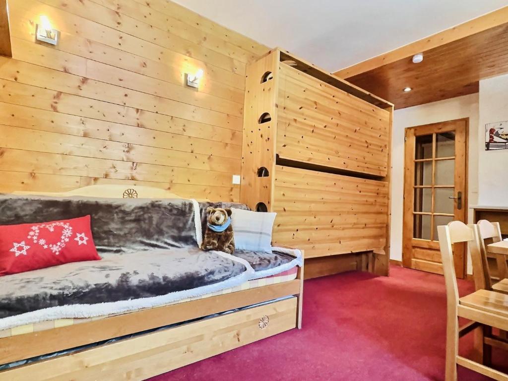 Cette chambre comprend un lit dans un mur en bois. dans l'établissement Studio Val-d'Isère, 1 pièce, 3 personnes - FR-1-411-200, à Val dʼIsère