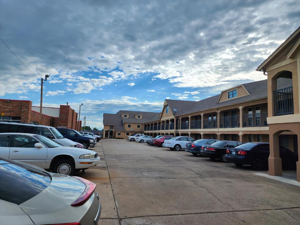 uma fila de carros estacionados em frente a um edifício em Executive inn em Oklahoma City