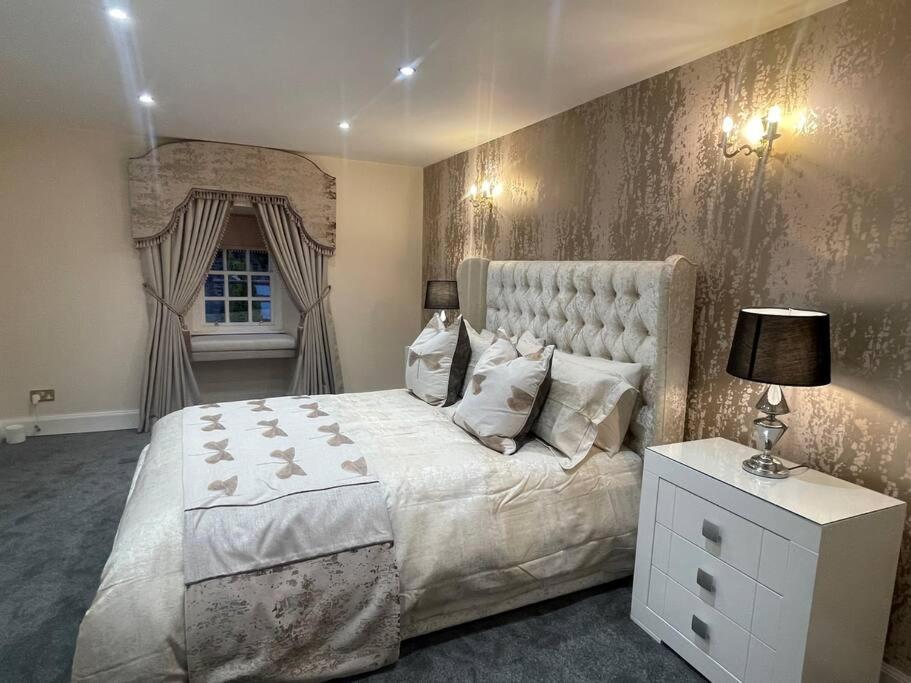 um quarto com uma cama grande e uma janela em Castle Gogar Cottage em Edimburgo