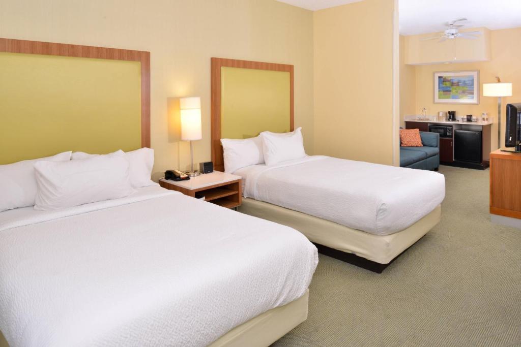 une chambre d'hôtel avec deux lits et un canapé dans l'établissement SpringHill Suites Pinehurst Southern Pines, à Pinehurst