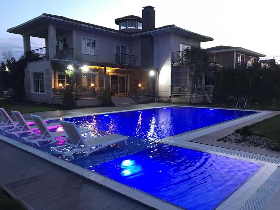 una piscina con sillas y una casa en Villa Greensea, en Büyükçekmece