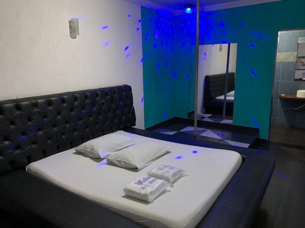 una camera da letto con un letto con due asciugamani sopra di Motel Jaguar Contagem a Contagem