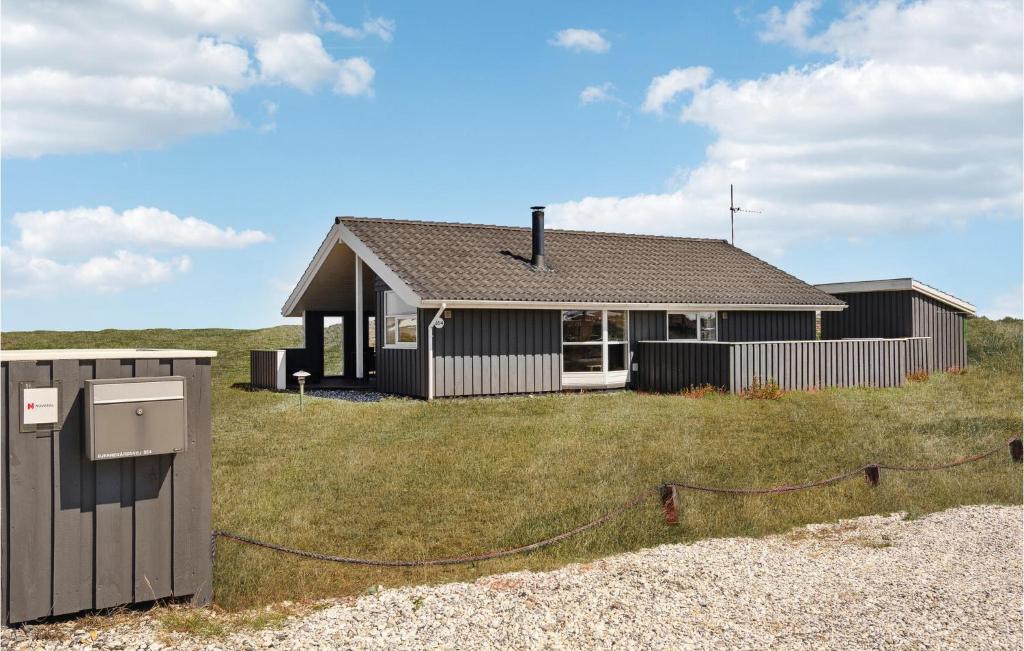 a small house on top of a grass field at Pet Friendly Home In Hvide Sande in Bjerregård
