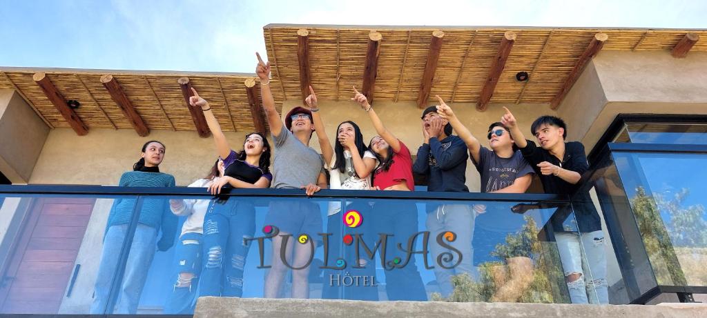Eine Gruppe von Menschen mit den Händen in der Luft. in der Unterkunft Hotel Tulmas in Tilcara