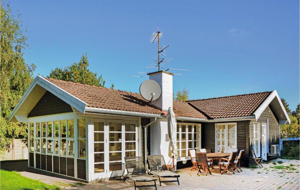 a house with a patio with a table and chairs at Amazing Home In Hornbk With Wifi in Hornbæk