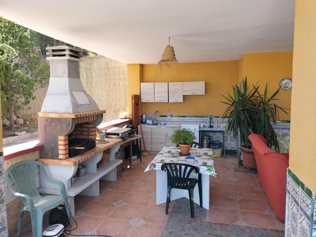 uma cozinha com uma mesa e um forno exterior em Vivienda Rural Villa Ruben em Jaén