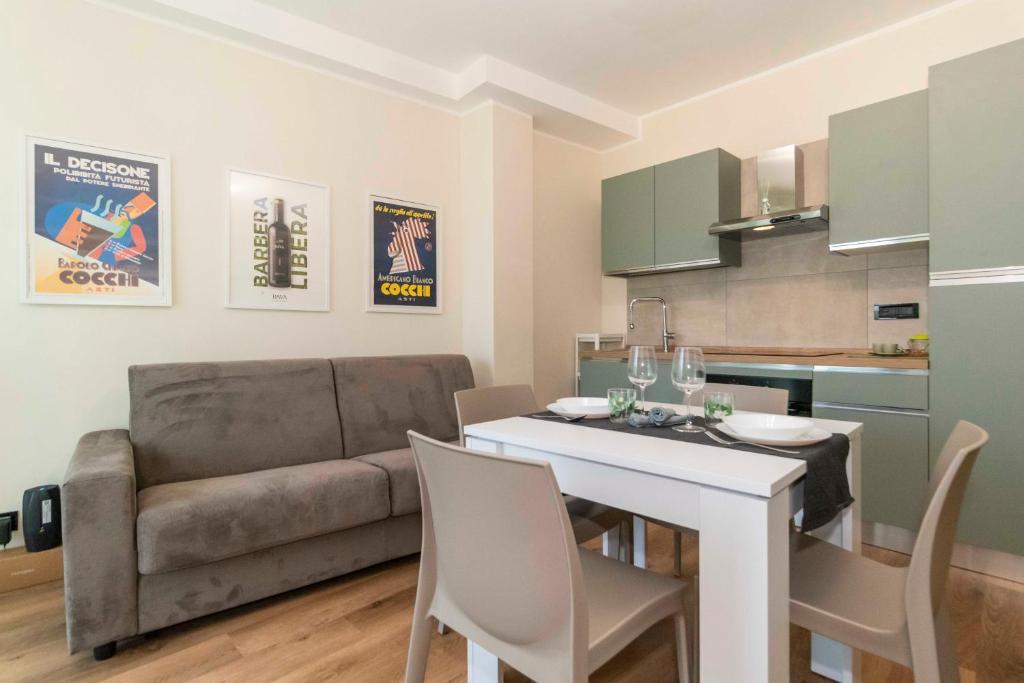 a kitchen and living room with a couch and a table at Torino Comfy Apt - w/ Private Parking in Turin