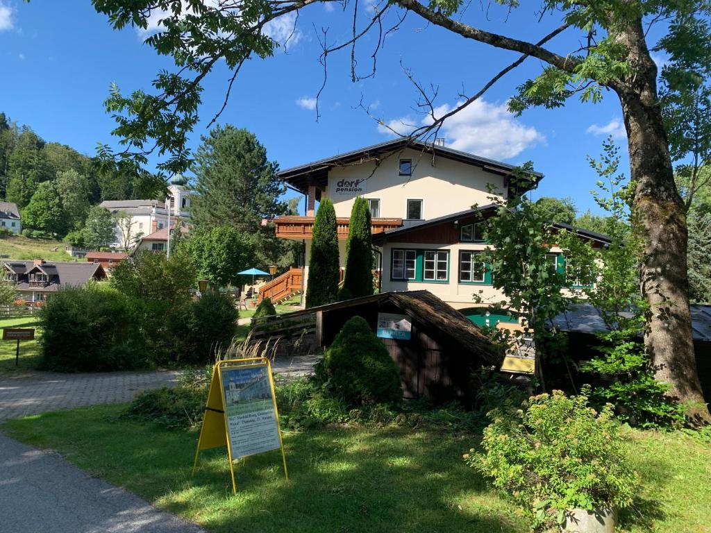 una casa con un cartel delante de ella en Dorfpension Mariahilfberg en Gutenstein