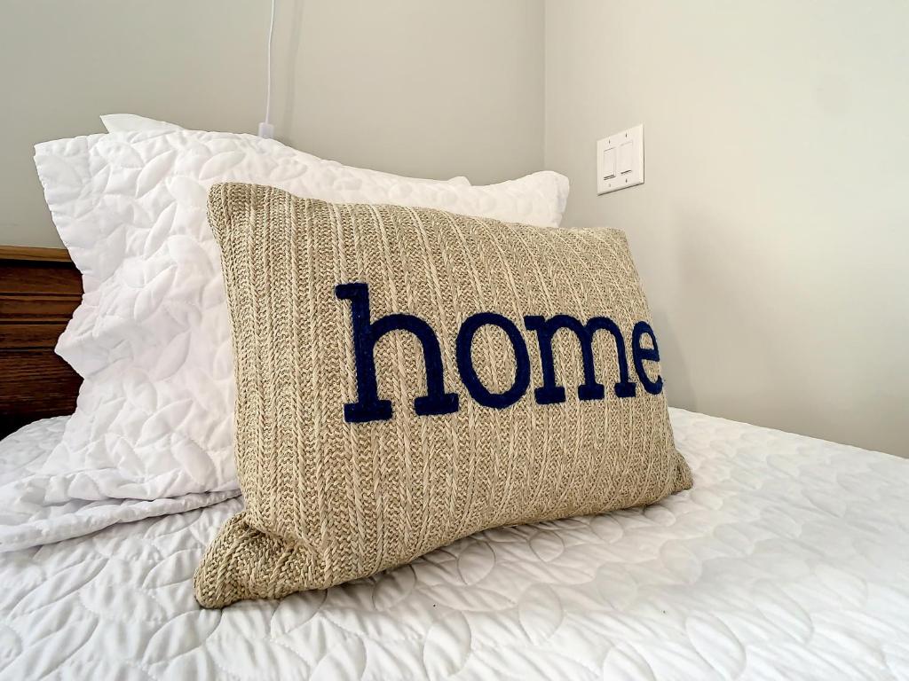 a pillow with the word home written on it on a bed at Close to Everything! Family & Pet Friendly Home - By the Park! in Saint Augustine