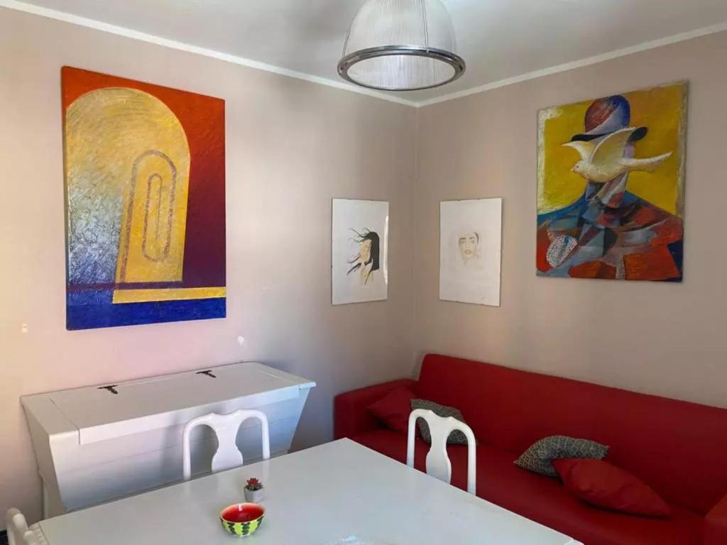 a living room with a red couch and some paintings at Casa in centro storico a Carrara in Carrara