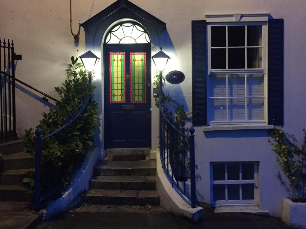 een huis met een blauwe deur en een glas-in-loodraam bij The Old Dispensary in Kinsale