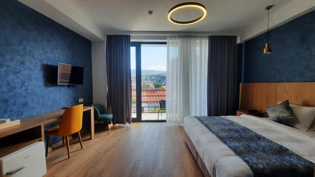 Habitación de hotel con cama, escritorio y ventana en Hotel DownTown Avlabari en Tiflis