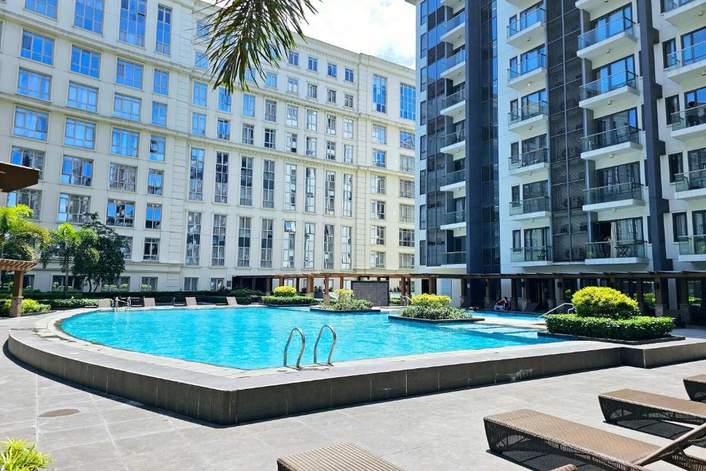 a swimming pool in the middle of some buildings at Tess and Tessha Condotel in Manila