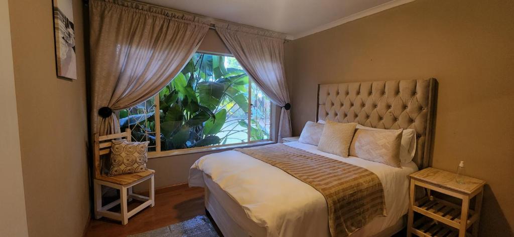 una camera con un grande letto e una finestra di Bozi Abode a Kempton Park