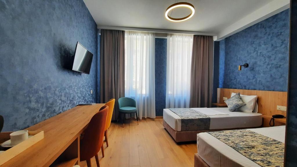 a hotel room with two beds and a desk at Hotel DownTown Avlabari in Tbilisi City