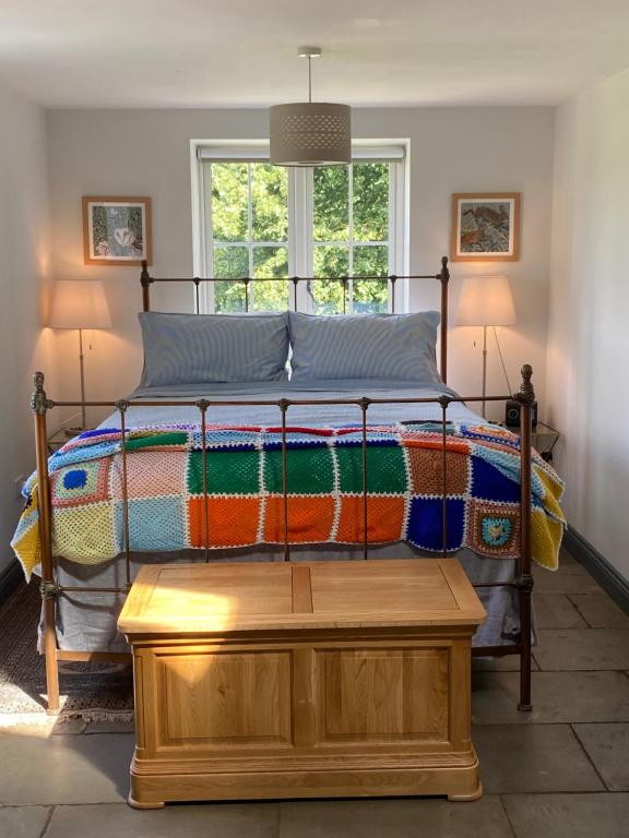 Un dormitorio con una cama con una manta de colores. en Worfe View Cottage, 