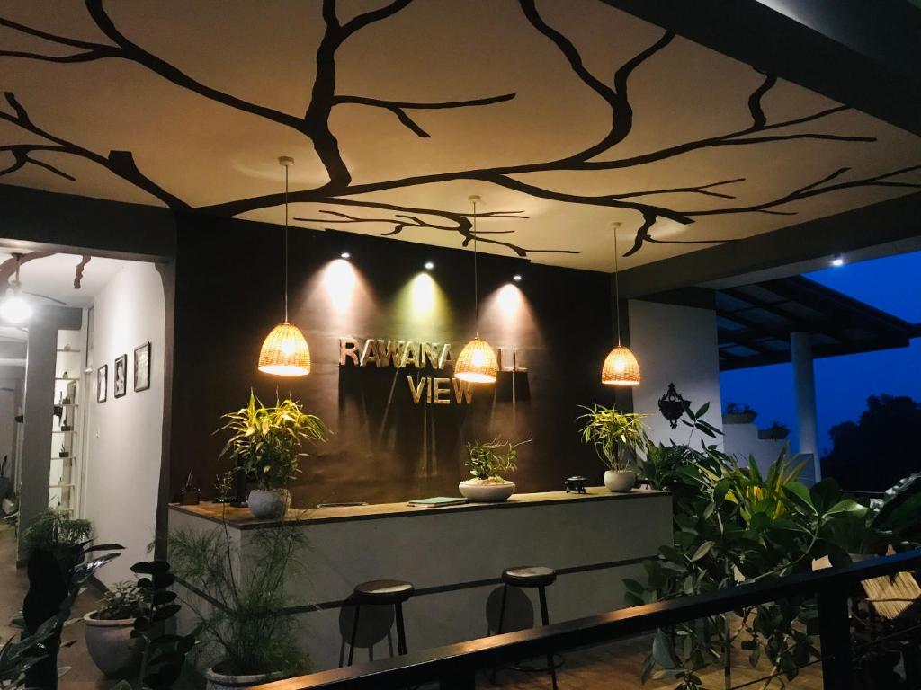 a restaurant with potted plants and lights on a wall at Rawana View Ella in Ella