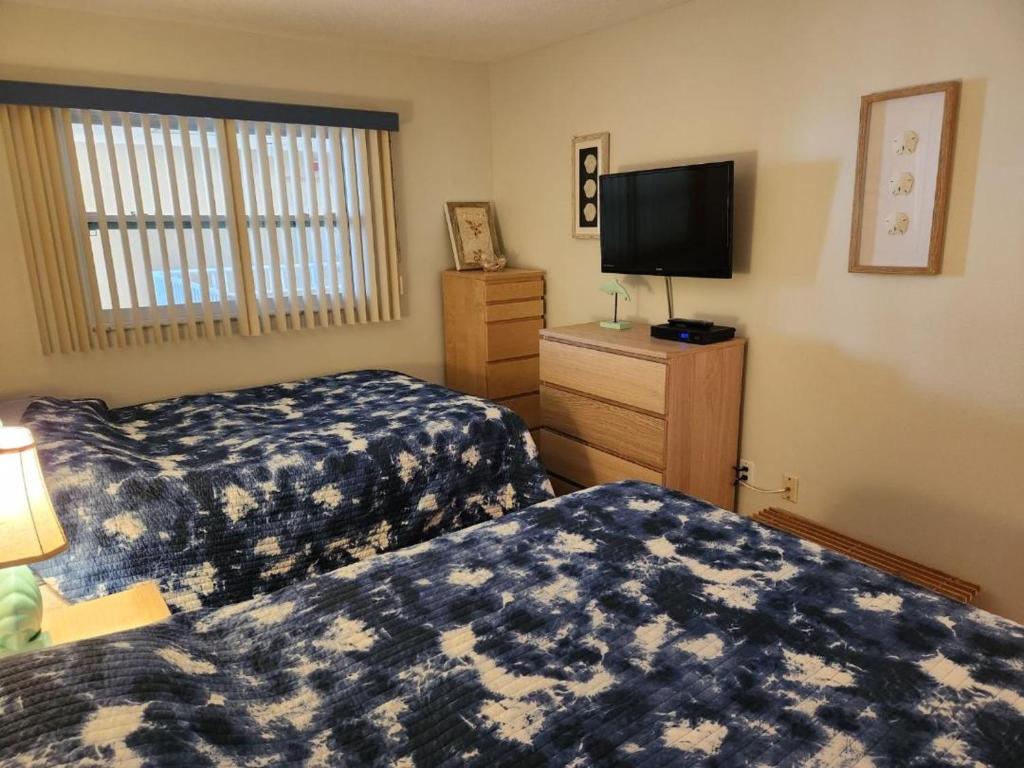 ein Hotelzimmer mit 2 Betten und einem Flachbild-TV in der Unterkunft Holiday Villas II ON THE BEACH w/Intercoastal View in Clearwater Beach