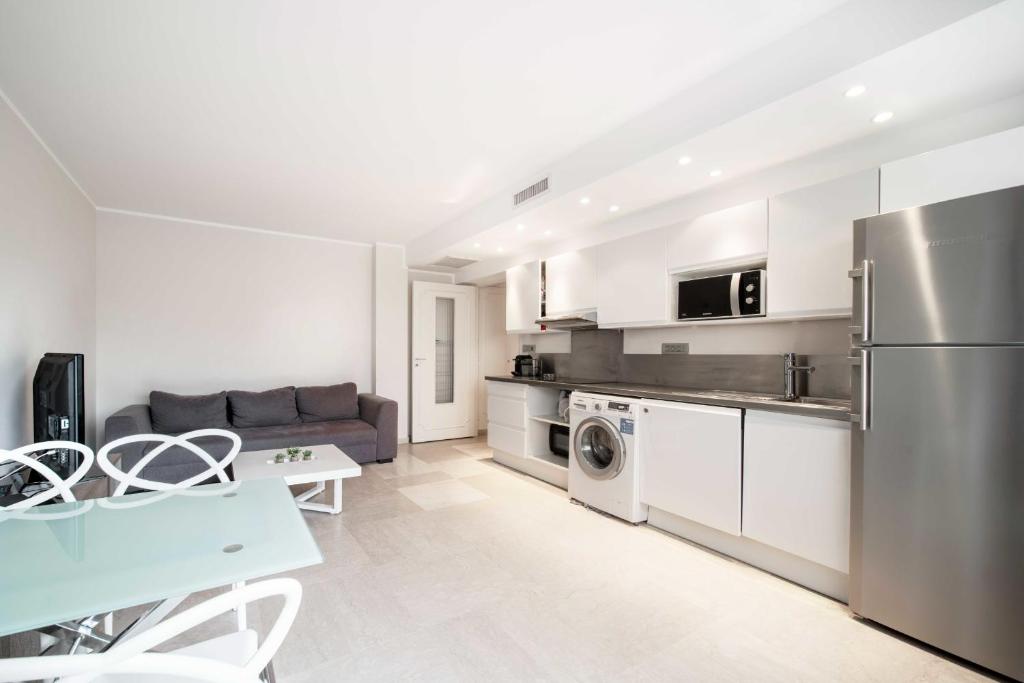 une cuisine et un salon avec un réfrigérateur en acier inoxydable dans l'établissement Magnifique appartement T3 centre Cannes, à Cannes