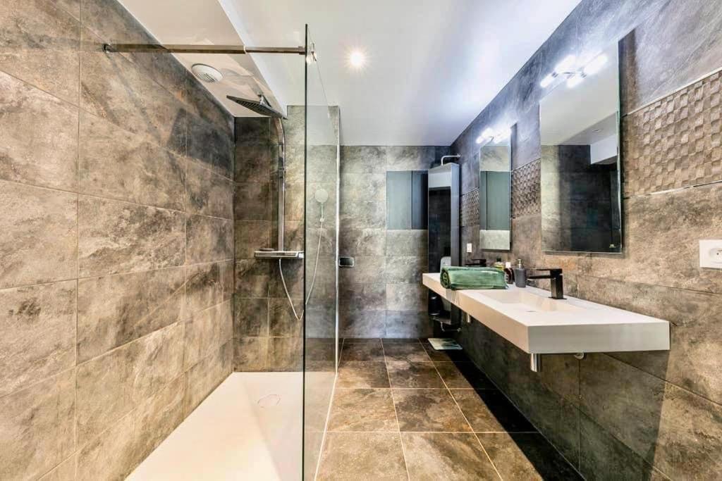 a bathroom with a sink and a glass shower at Penthouse 120 m2 vue imprenable Lattes in Lattes