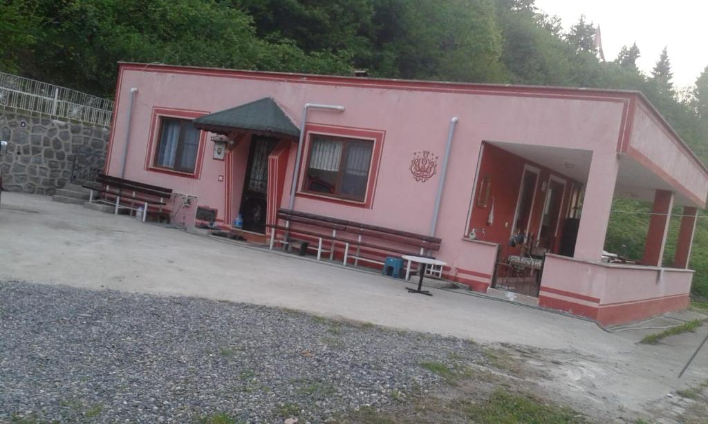 un edificio rosa con panchine di fronte di Ayten's Sweet House a Trabzon