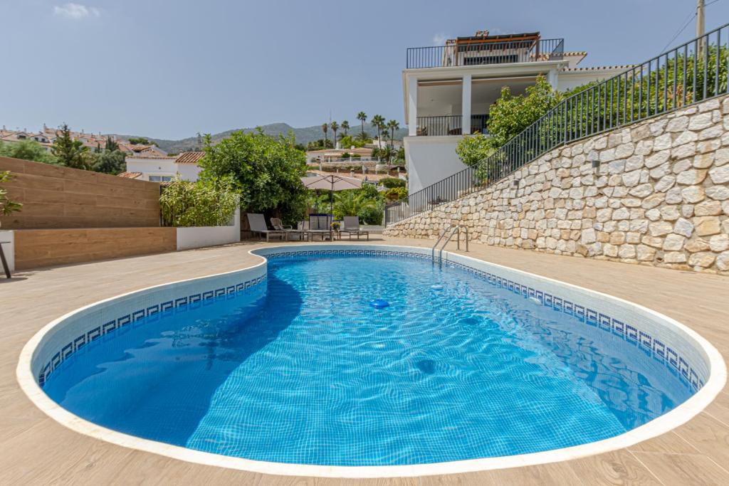 basen z niebieską wodą przed budynkiem w obiekcie Luxury Top Villa Alhambra Pool close to Sea and Centre w mieście Benalmádena
