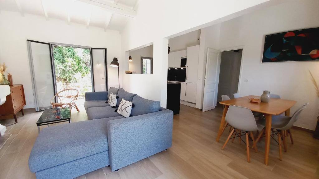 ein Wohnzimmer mit einem blauen Sofa und einem Tisch in der Unterkunft Villa Everblue Sainte-Maxime - Domaine privé - Piscine in Sainte-Maxime
