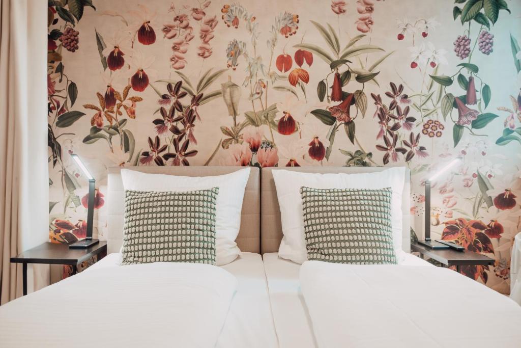 1 dormitorio con 2 camas y papel pintado con motivos florales en House of Blooms en Fulda