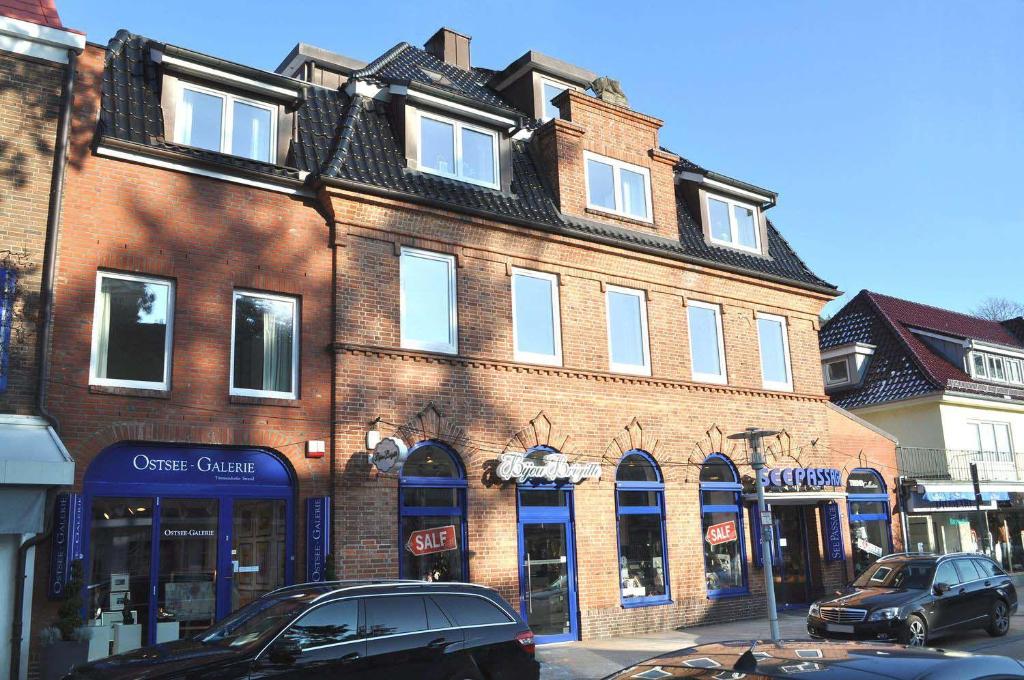 a large brick building with cars parked in front of it at Seepassage Ferienwohnung Nr 02 in Timmendorfer Strand