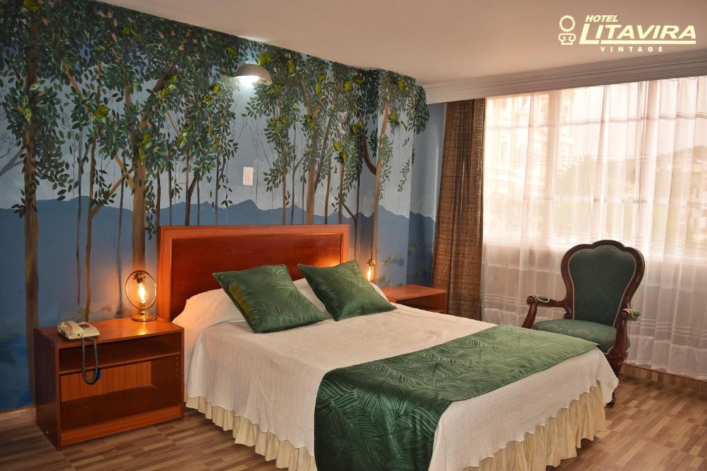 um quarto com uma cama e um mural de árvore em Hotel Litavira Vintage em Sogamoso