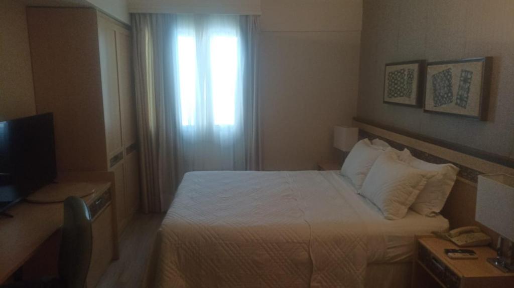 Una habitación de hotel con una cama y una ventana. en Let's Apto 813, en Brasilia