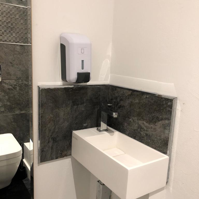 a bathroom with a sink and a soap dispenser on the wall at Penthouse 120 m2 vue imprenable Lattes in Lattes