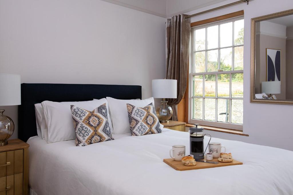 a white bed with a tray of food on it at The Bakery in Arundel