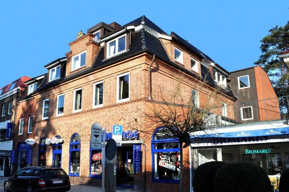 duży ceglany budynek po stronie ulicy w obiekcie Seepassage Ferienwohnung Nr 03 w mieście Timmendorfer Strand