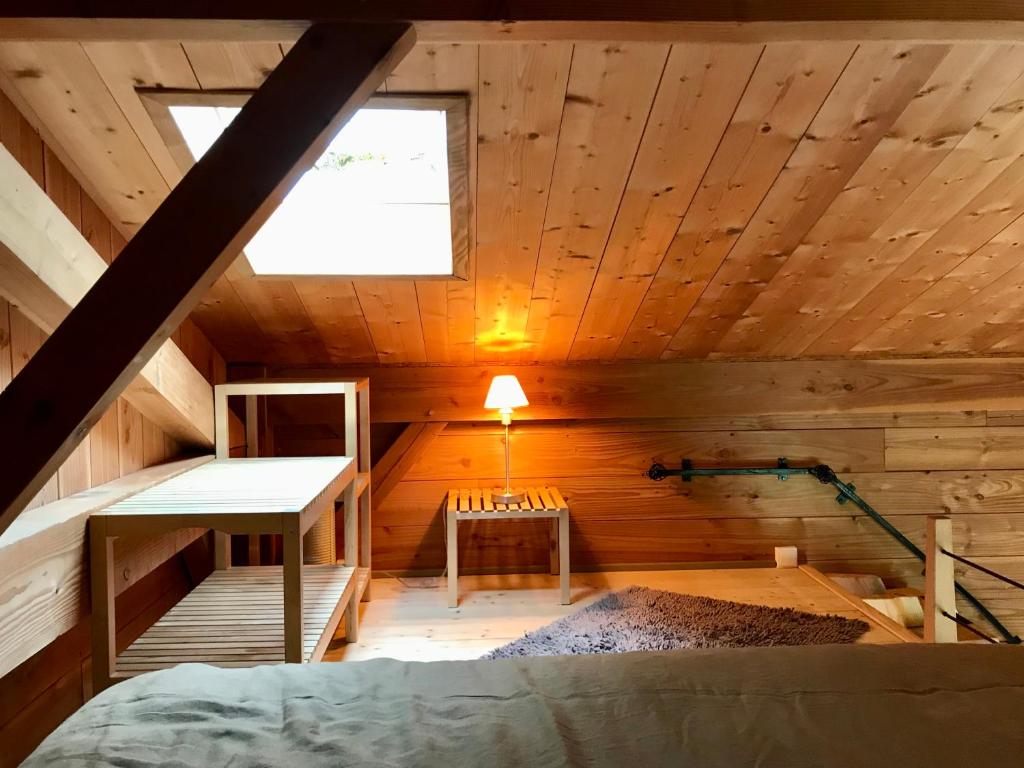 an attic room with a bed and a window at Gîte Le Mazot de Vouan in Saint-André-de-Boëge