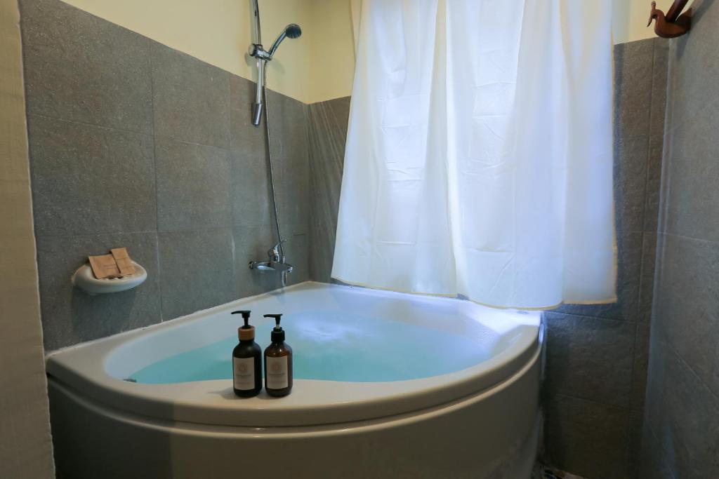 two bottles of wine sitting on top of a bath tub at Phongsavath Boutique Hotel in Vientiane
